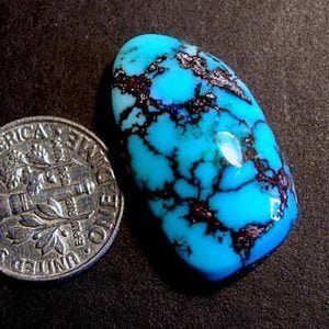 سنگ فیروزه ای کوچک به اندازه یک سکه دایم آمریکا فیروزه ای با رگ های متعدد در داخل خودش به زیبایی به چشم میخورد.